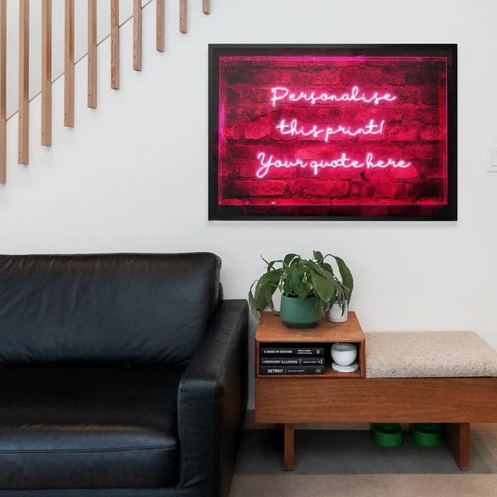 Custom neon-style wall art print featuring glowing pink handwritten text on a dark red brick background in a black frame.