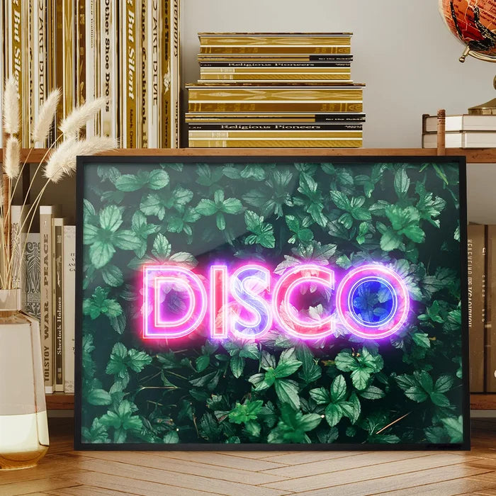 Framed wall art featuring a glowing pink and purple neon DISCO sign layered over a vibrant green botanical leaf background.