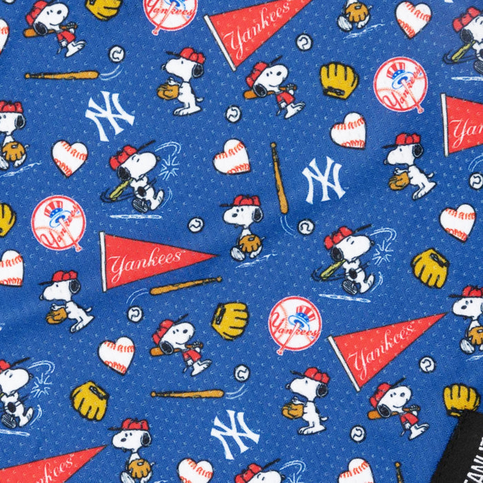 The Sassy Woof Dog Bandana - MLB™ x Peanuts™ New York Yankees™ features blue fabric with Snoopy in a baseball uniform, Yankees logos, and fun sports motifs—perfect for a unique dog accessory!.