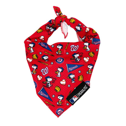 The Sassy Woof Dog Bandana - MLB™ x Peanuts™ Washington Nationals™ features team logos, Snoopy baseball designs, and pennants on red fabric, finished with a top knot and an MLB x Peanuts tag at the bottom.