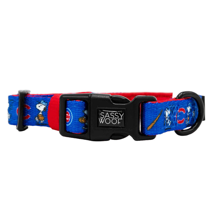 The Sassy Woof Dog Collar - MLB™ x Peanuts™ Chicago Cubs™ features playful baseball cartoon designs in blue and red, with a black plastic buckle. Perfect adjustable collar for Cubs fans and their pups!.
