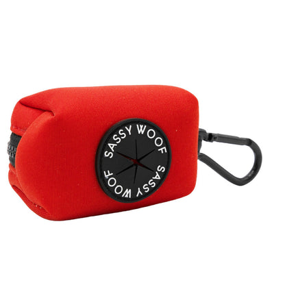 A red rectangular pouch with a black zipper, clip, and round Sassy Woof label—designed to match your Sassy Woof Dog Four Piece Bundle - Neon Red harness, adjustable harness, and collar.