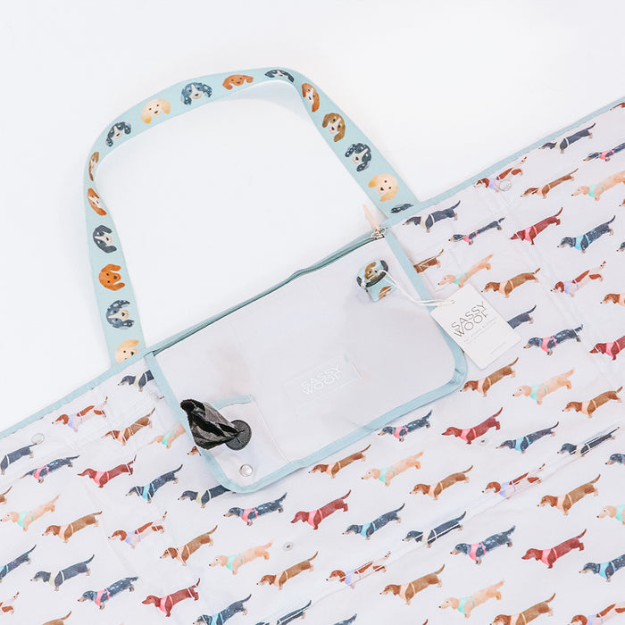 Carry your Sassy Woof Dog Picnic Blanket - Dainty Dachshunds in style with this playful tote, featuring a colorful dachshund pattern, handle dog face print, a handy pocket, and a “Sassy Woof” tag—perfect for outdoor adventures.