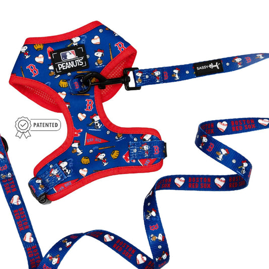 The Sassy Woof Dog Two Piece Bundle - MLB™ x Peanuts™ Boston Red Sox™ features a blue/red harness and leash with Snoopy, hearts, team logos, and an official Peanuts MLB tag. Leash reads "Boston Red Sox." Includes a Patented badge.