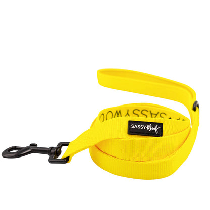 The Sassy Woof Dog Two Piece Bundle in Neon Yellow includes a bright leash with a black metal clasp and matching harness, both designed for comfort and control—perfect for stylish dog walks.
