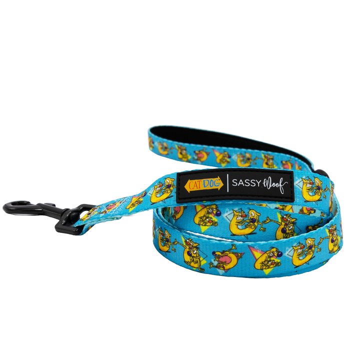 The Sassy Woof Dog Two Piece Bundle - Nickelodeon CatDog™ features a bright blue leash with playful cartoon cat prints, black hardware, and labels reading CAT DOG and SASSY WOOF. Part of the fun CatDog collection.