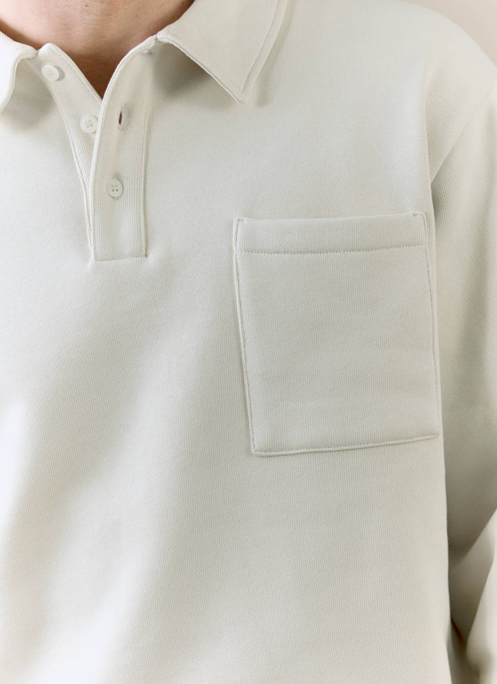 A close-up of the Percival Dudley Boxy Sweatshirt in cream, showing the polo collar and chest pocket detail.