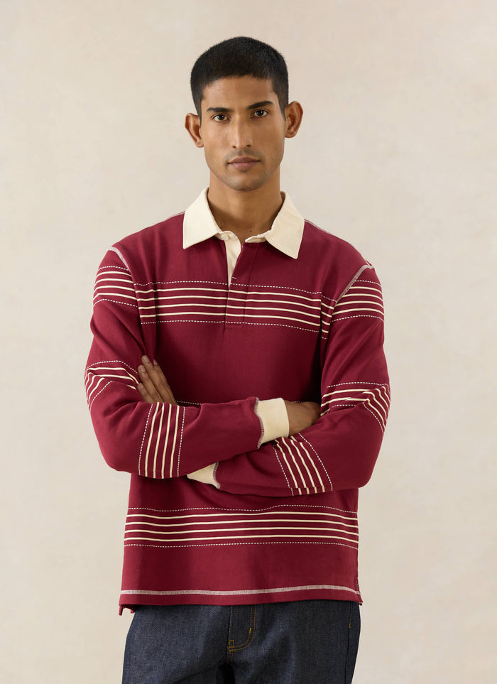 The Percival Editor Striped Rugby Polo in burgundy cotton with cream collar and stab stitched stripes and raw indigo denim.