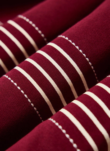Detailed white stab stitching and stripes on the burgundy cotton Editor Rugby Polo from the Percival new season.