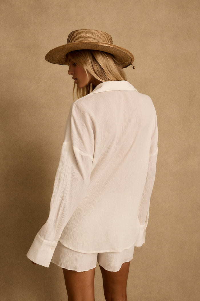 Back view of ivory gauze tie top with matching shorts and straw sun hat.