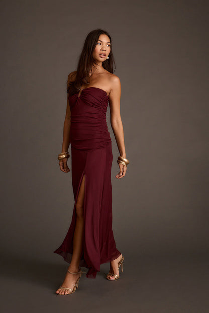 Burgundy strapless mesh maxi dress with a ruched bodice and thigh-high slit.