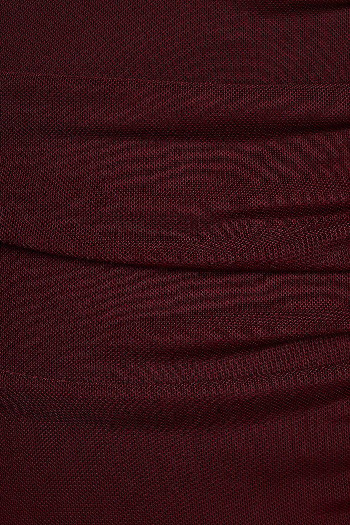 Close-up of burgundy mesh fabric with soft draped folds.
