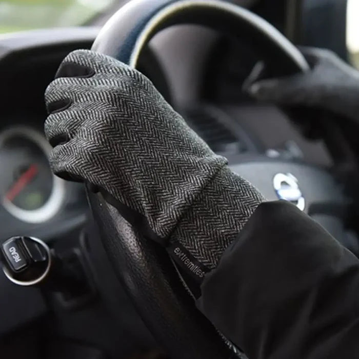 Lifestyle image of a person wearing Extremities Herringbone touchscreen thermal liner gloves whilst driving a car