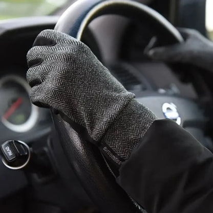 Lifestyle image of a person wearing Extremities Herringbone touchscreen thermal liner gloves whilst driving a car