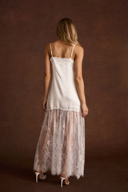 Back view of a white satin slip dress with a lace trim neckline and adjustable straps.
