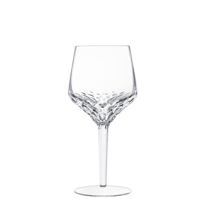 A clear Folia Stemware wine glass by Saint-Louis/Hermès, featuring a textured, patterned bowl and a smooth, slender stem, stands upright against a plain white background. Expertly mouthblown and hand-cut, this elegant piece highlights exquisite craftsmanship.