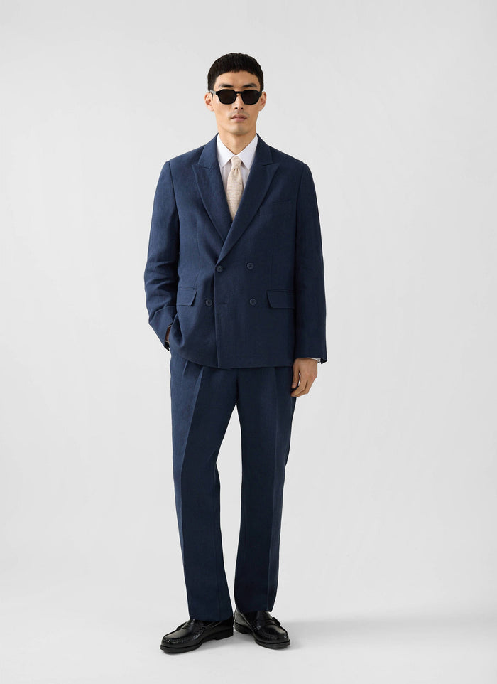 The Percival Formal Classic Shirt in white, styled on a model under a navy double-breasted suit with sunglasses.