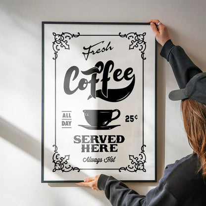 Fresh Coffee Served Here Print being hung on a wall in a black frame
