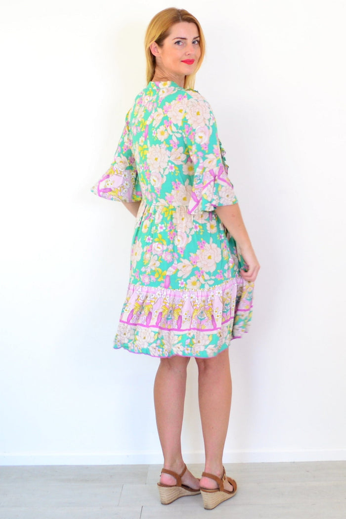 Green floral print bohemian tunic dress by Dream with flowing fabric and vibrant botanical patterns.