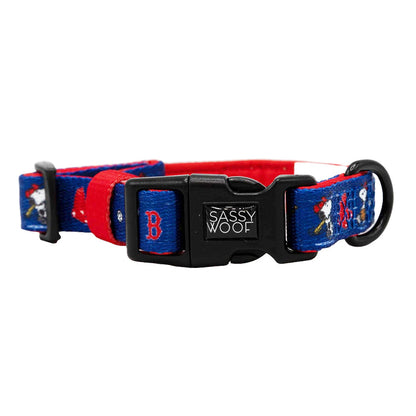 The Sassy Woof Dog Collar - MLB™ x Peanuts™ Boston Red Sox™ features a blue and red adjustable design, black plastic buckle, and playful dog, baseball, and "B" graphics—ideal for any Boston Red Sox or Peanuts fan's dog accessories collection.