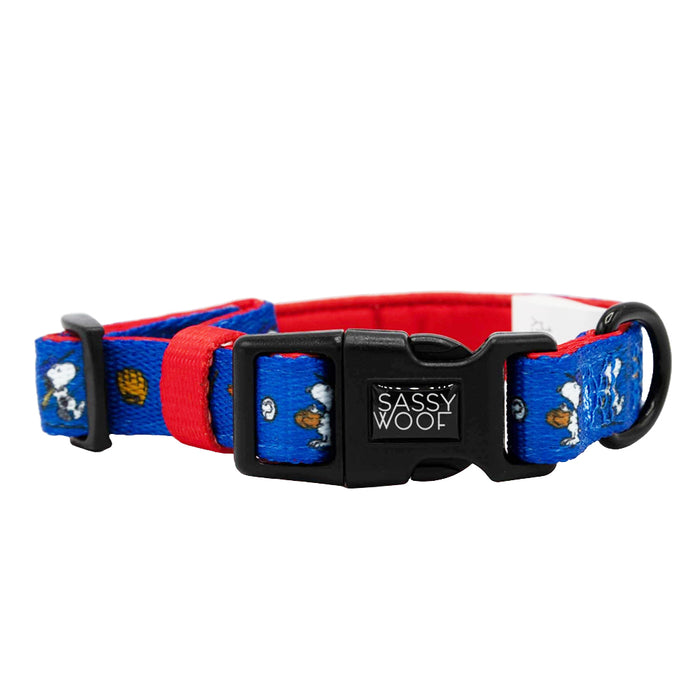 The Sassy Woof Dog Collar - MLB™ x Peanuts™ Los Angeles Dodgers™ is blue and red with a black buckle, D-ring, Sassy Woof label, and features a cartoon Snoopy on the blue strap.