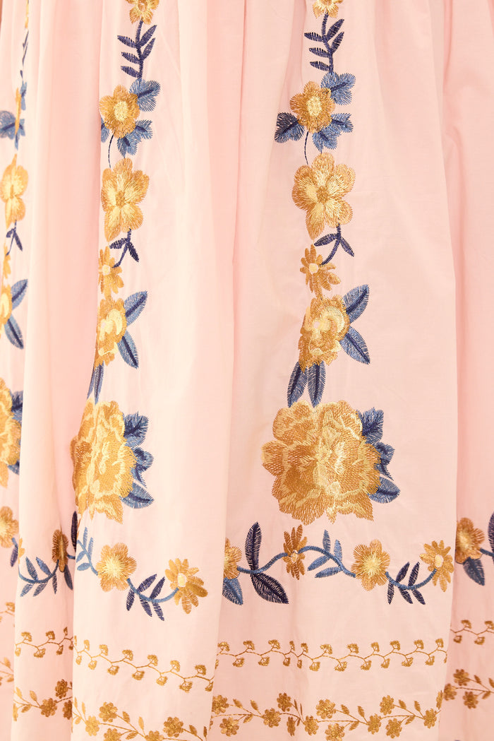 Floral embroidery on a pink fabric background