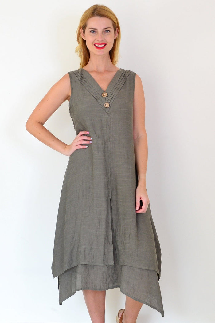 Khaki sleeveless tunic dress with coconut button details from La Mode, shown hanging on a wooden hanger.