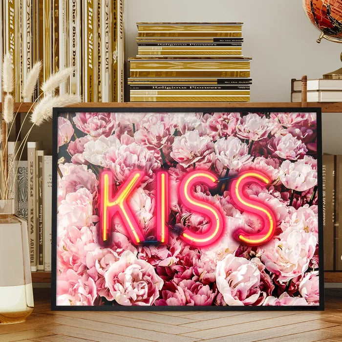 Framed wall art featuring a glowing pink neon KISS sign layered over a vibrant background of soft pink roses.