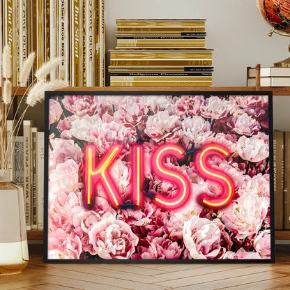 Framed wall art featuring a glowing pink neon KISS sign layered over a vibrant background of soft pink roses.