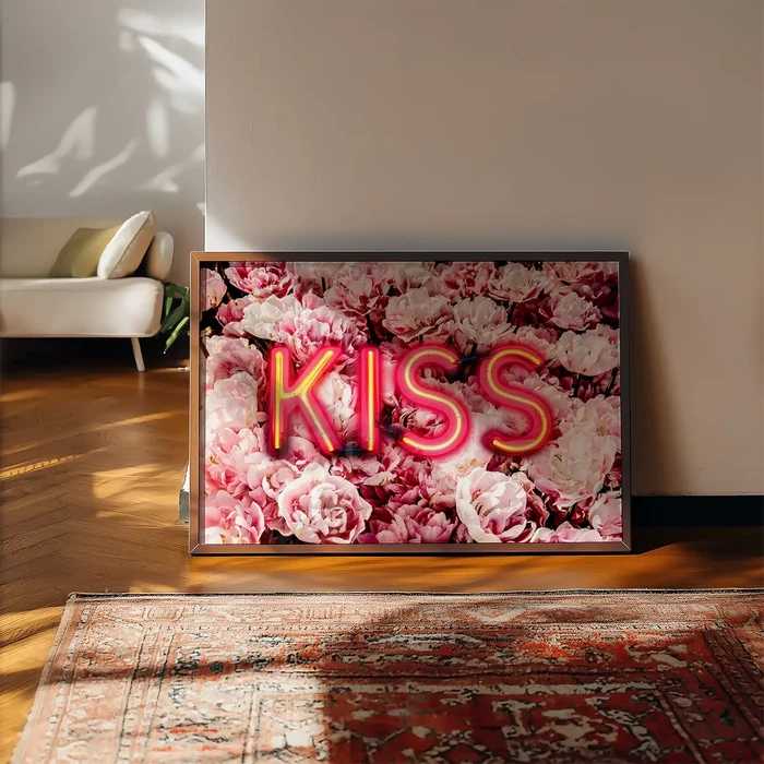 Framed print featuring the word KISS in bright neon letters layered over a lush background of pink roses.