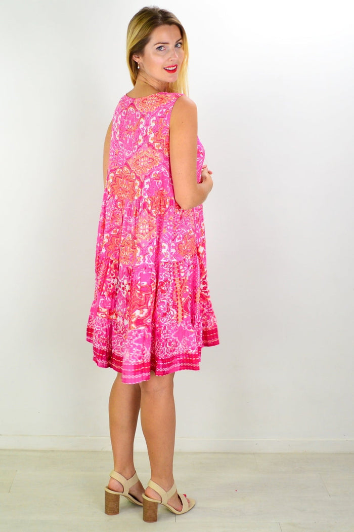 Orientique Kotor tiered tunic dress hanging on a hanger, featuring layered fabric and a relaxed, bohemian style.