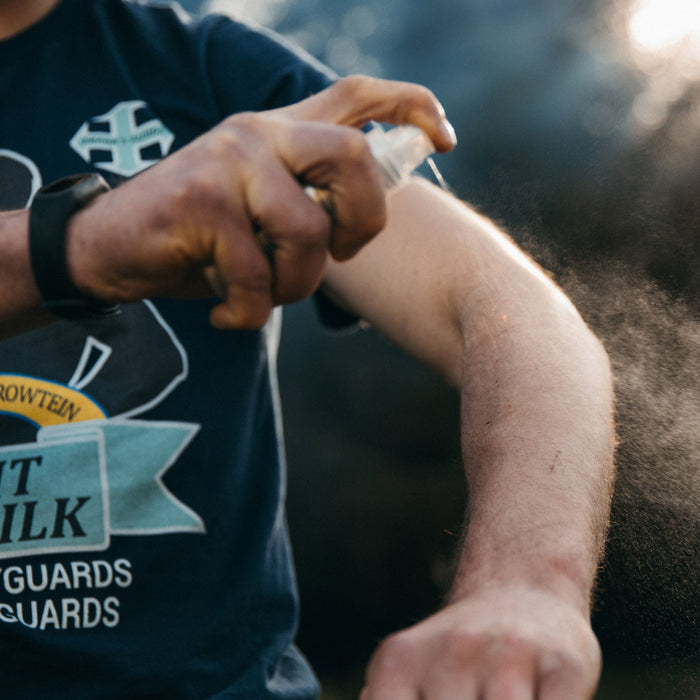 Lifesystems DEET free midge repellent being sprayed on to a mans arm whilst outdoors