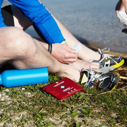 Lifesystems Light And Dry Nano First Aid Kit being used by a runner to treat a foot blister