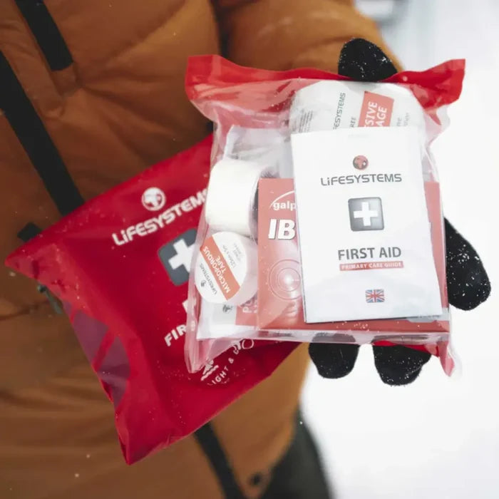 Lifesystems Light And Dry Pro First Aid Kit being held in someones hand in the snow