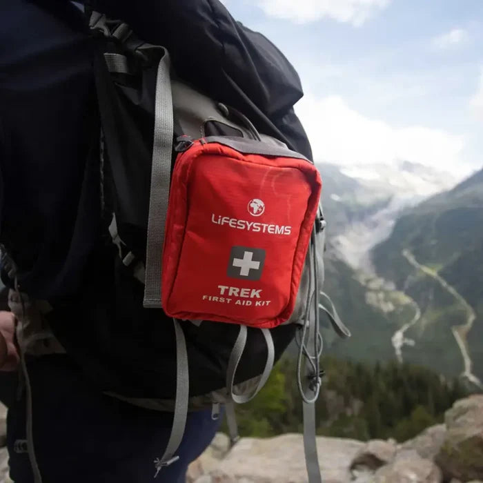 Lifesystems Trek First Aid Kit attached to a backpack with a mountainous landscape in the background