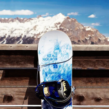 Snowboard secureds against a wooden fence with a Lifeventure 4 Dial Adjustable Cable Lock with mountainous background