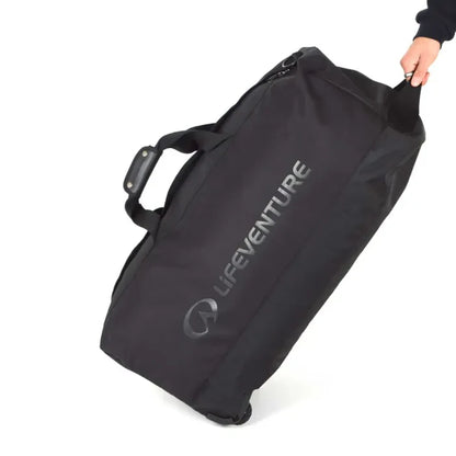 Lifeventure Expedition Wheeled Duffle Bag 120 Litres in black being pulled by the handle on a white background