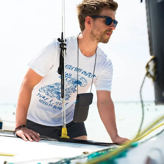 Lifetyle image of a man wearing a Lifeventure waterproof chest wallet in the sun whilst sailing