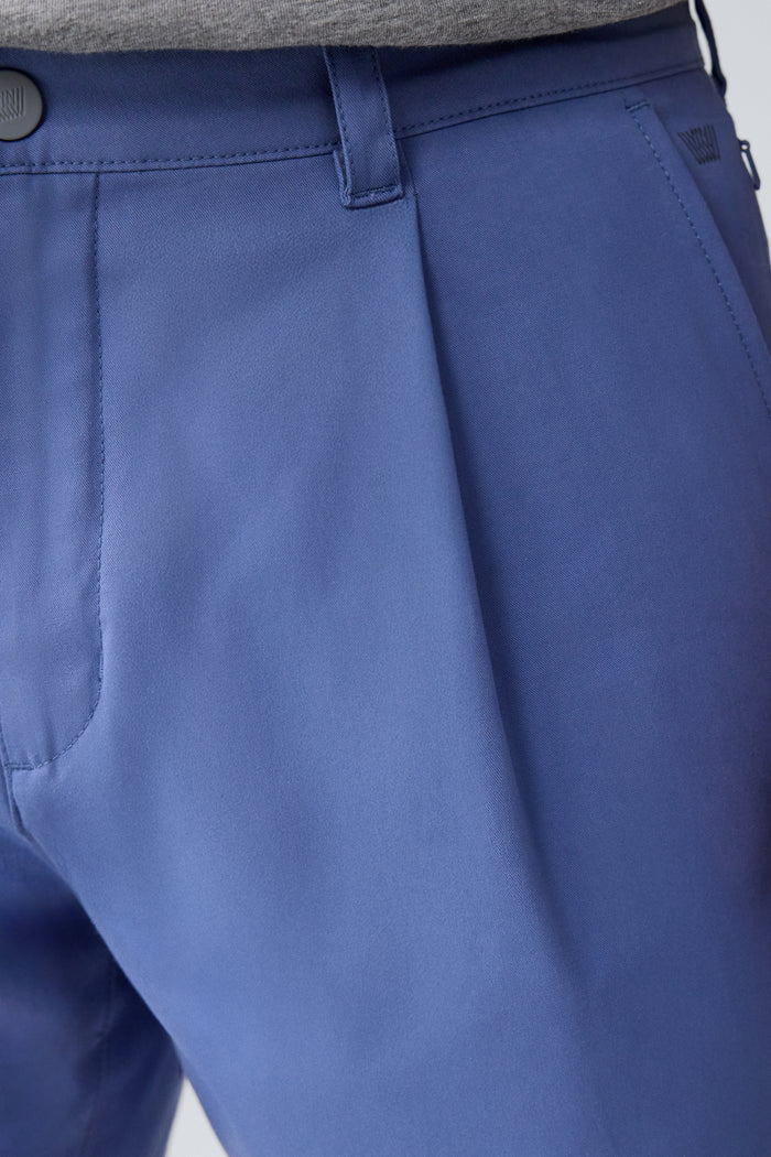 Close up view of a man wearing Maverick Tech Chino Pleated Short in Wild Rapids
