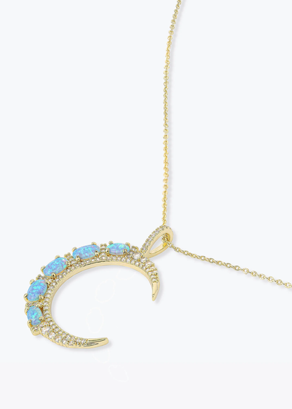 Gold necklace with a gold moon pendant with blue opal studs
