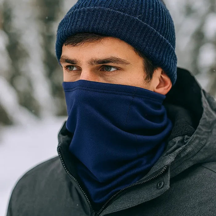 Man wearing a Sub Zero Meraklon Thermal Head Over In navy with a knitted hat outdoors in the snow.