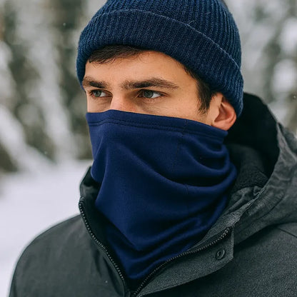 Man wearing a Sub Zero Meraklon Thermal Head Over In navy with a knitted hat outdoors in the snow.
