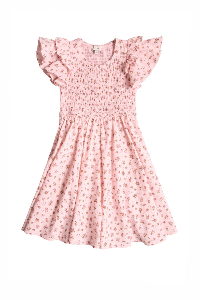 The Mini Hattie Dress in Madeline Pink by Ivy City Co is a light pink girls’ cotton dress featuring ruffled sleeves, a smocked bodice, and a delicate small floral print.