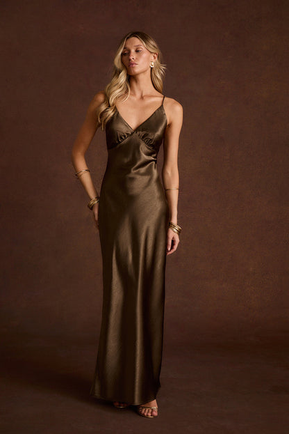 Bronze V-neck satin slip midi dress with thin straps and gold bangle bracelets.