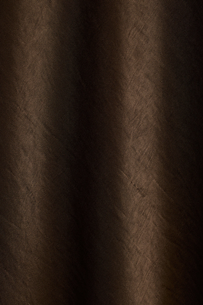 Close-up of dark bronze satin fabric with soft draped folds.