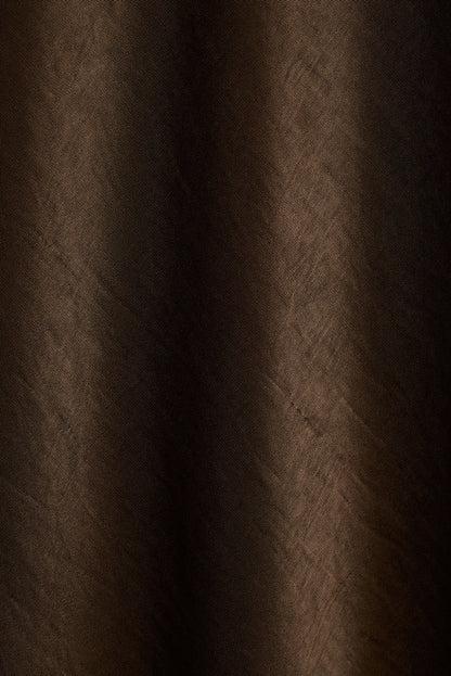 Close-up of dark bronze satin fabric with soft draped folds.