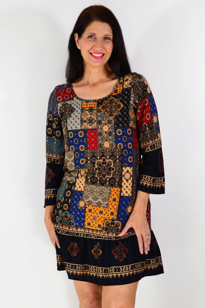 Moroccan mosaic tunic dress by Hourglass featuring vibrant patterns and flowing fabric, displayed on a hanger.