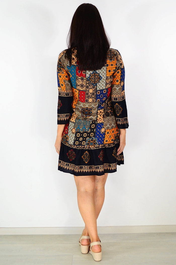 Colorful Moroccan mosaic-patterned tunic dress by Hourglass, featuring intricate designs and a flowing silhouette.