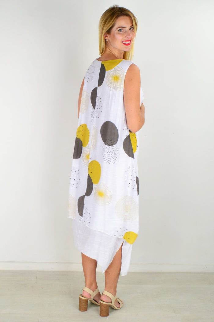 Mustard spot sleeveless tunic dress by La Mode displayed hanging with a flowing fit and round neckline.