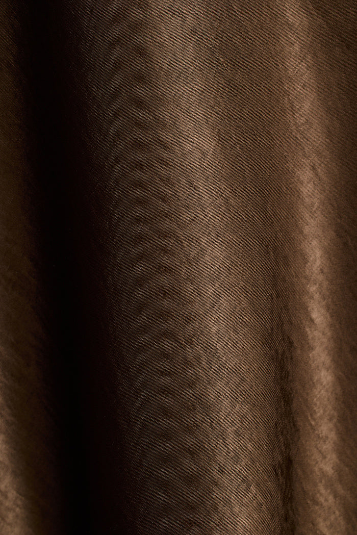 Close-up of brown satin fabric with soft draped folds.